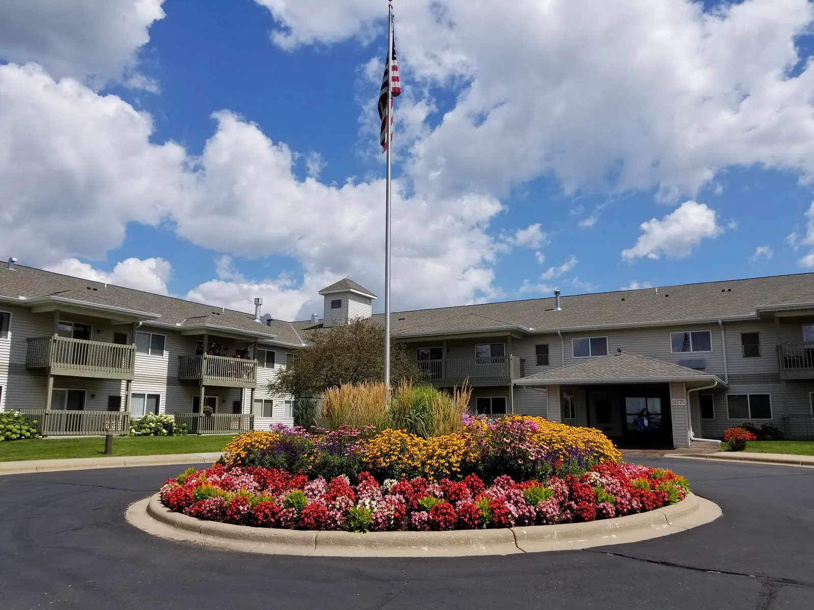 Front entrance of Realife Cooperative of Burnsville with flower bed and flagpole
